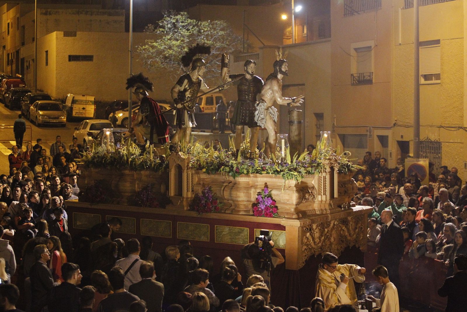 El Santísimo Cristo de la Paz en su Flagelación rodeado de fieles mientras reviraba encarando la calle de Sierra de Gredos.