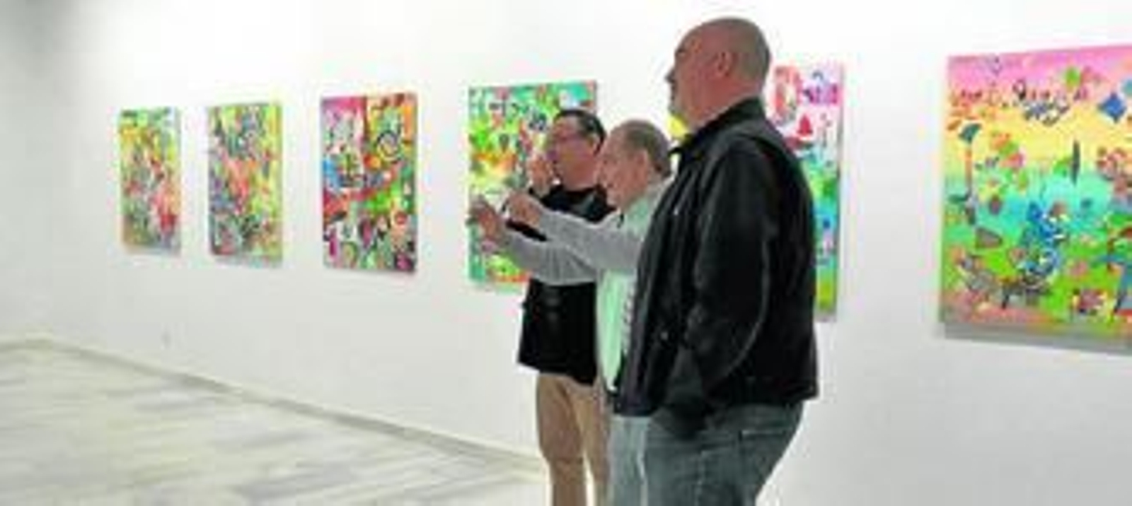 El pintor Fernando Parrilla explica al director del museo y al concejal de Cultura de Nerva su obra.