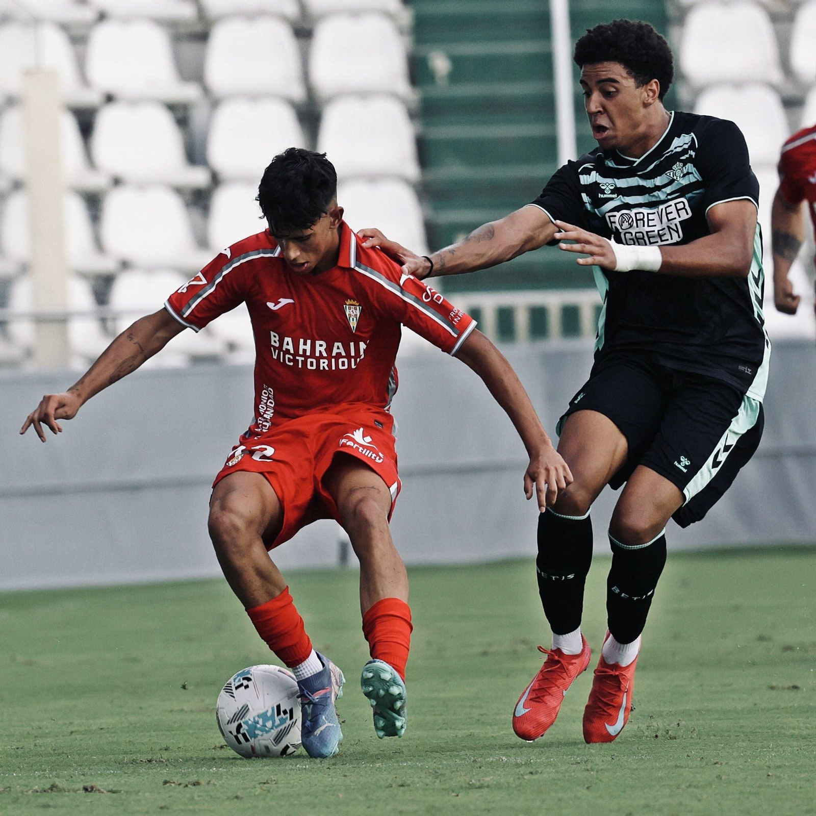 Albuera protege un balón ante un atacante bético.