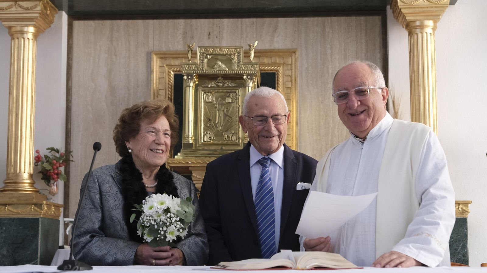 La pareja junto al párroco Julio Ruiz dándose ‘el sí quiero’.