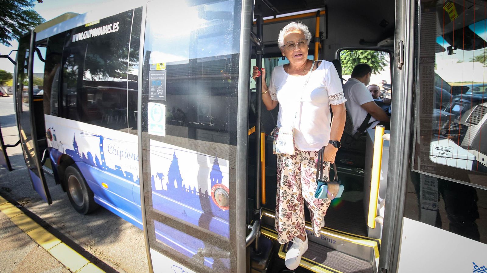 Manuela Vega, sevillana de 72 años, en la puerta del autobús urbano de Chipiona.