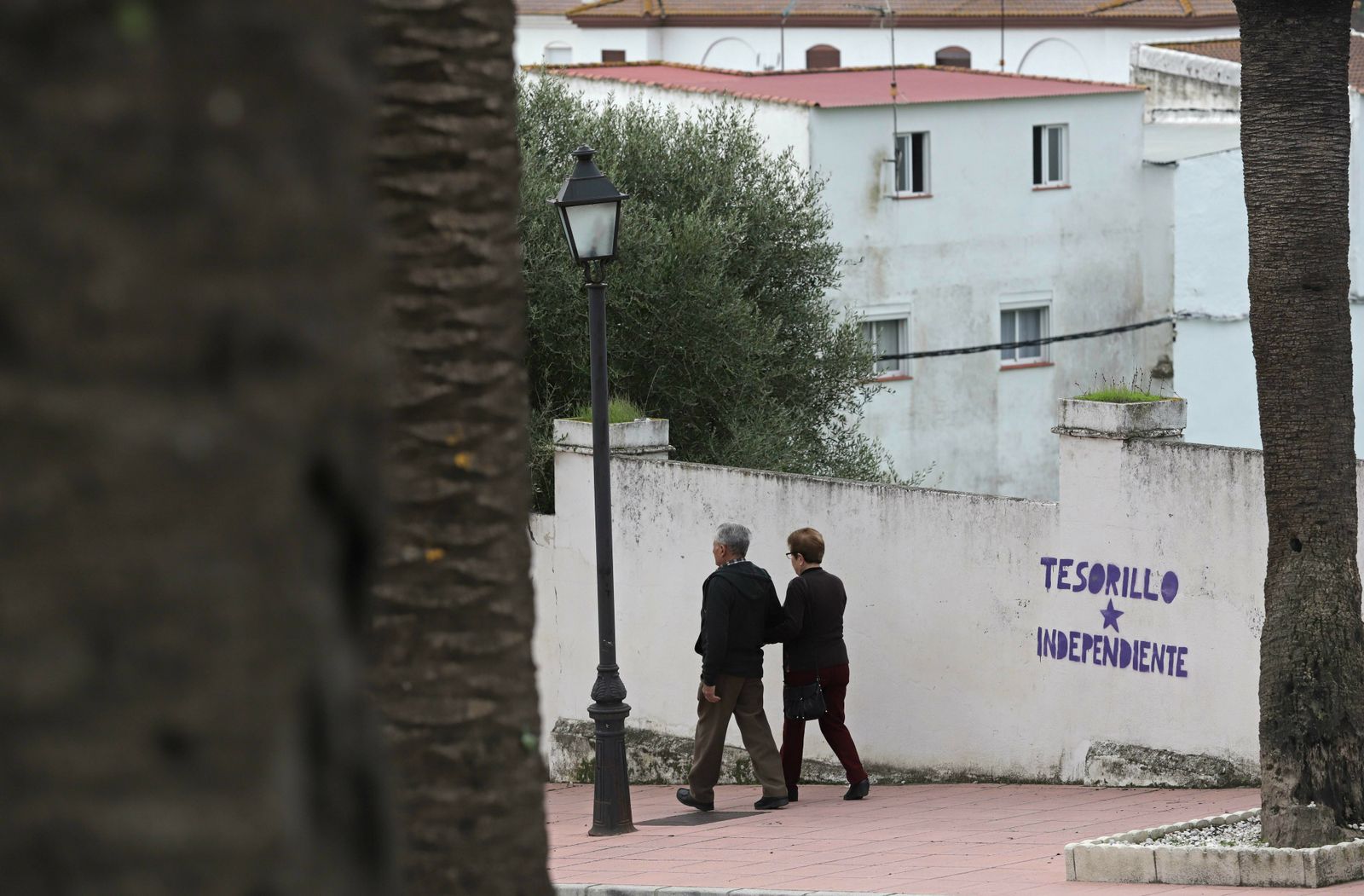 Dos personas caminan por una calle de San Martín del Tesorillo.