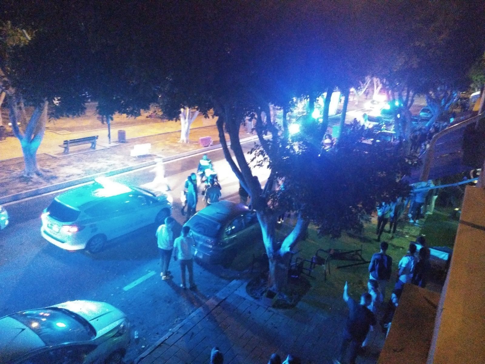 Coches de la Policía, afectados y curiosos tras la revuelta de la madrugada del sábado.