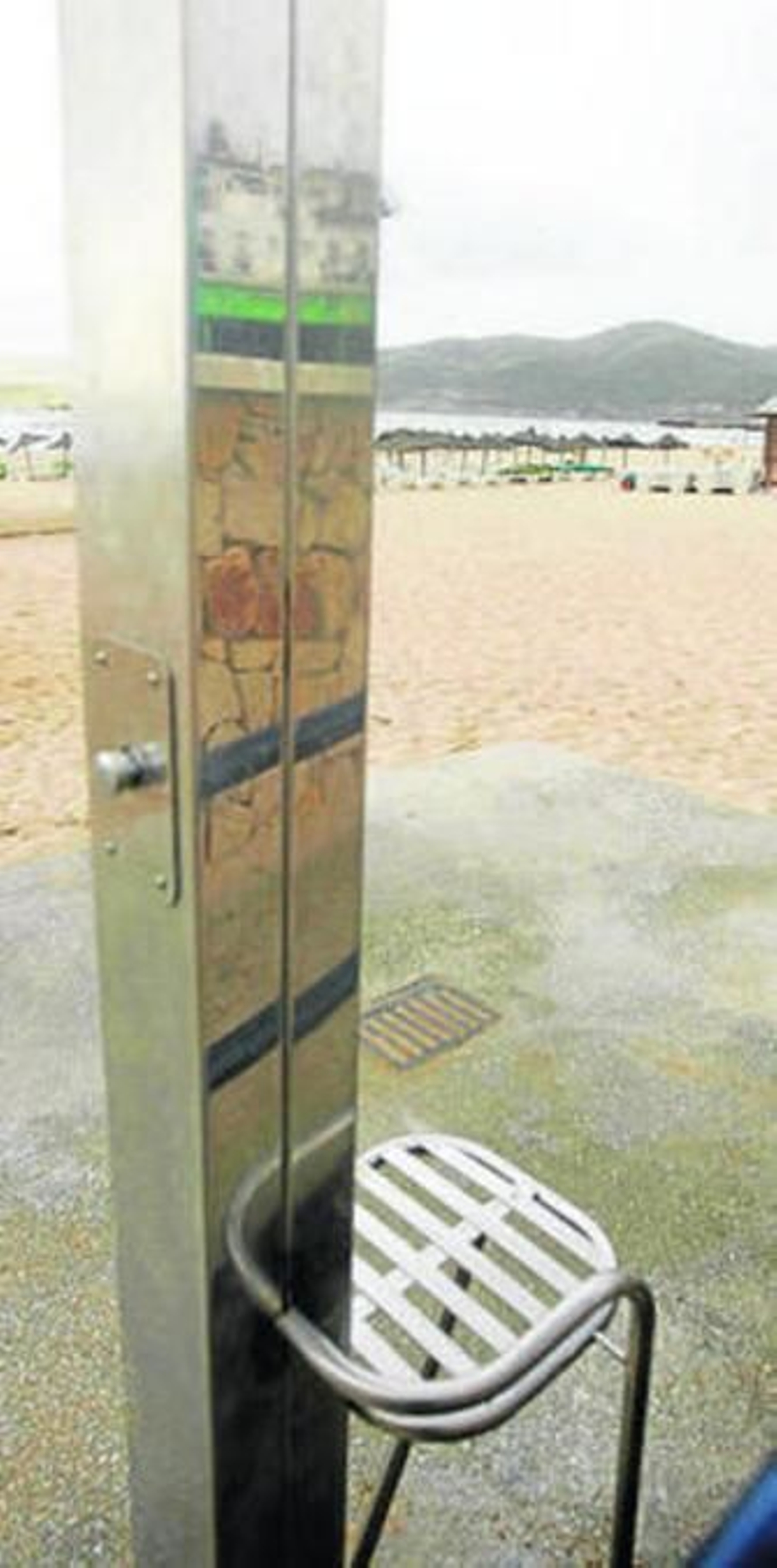 1. Vista de una de las pasarelas que se encuentran en la arena de la playa algecireña de Getares y que facilita el acceso. Junto a la rampa se observa una de las zonas de sombra donde pueden descansar las personas discapacitadas  2. Detalle de la silla de una ducha adaptada que se encuentran en la playa algecireña de Getares. 3. Imagen de una de las rampas de acceso a la playa, junto a una de las pasarelas que lleva hasta la orilla. Al lado se observa una de las duchas adaptadas a personas de movilidad reducida que hay por esta playa.