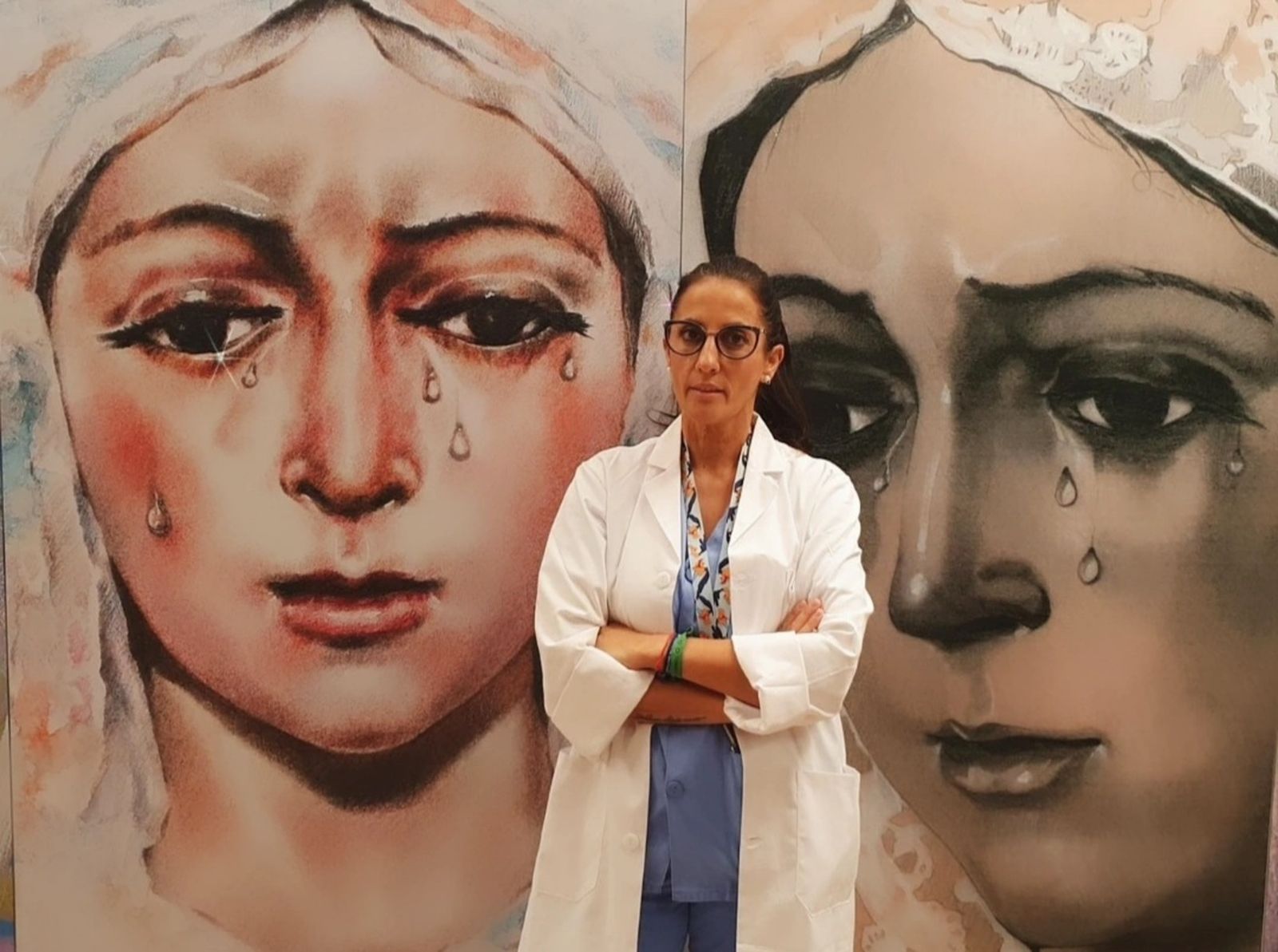 La enfermera Noelia Velasco ante las pinturas de la Virgen Macarena instalados en el pasillo de acceso a la UCI.