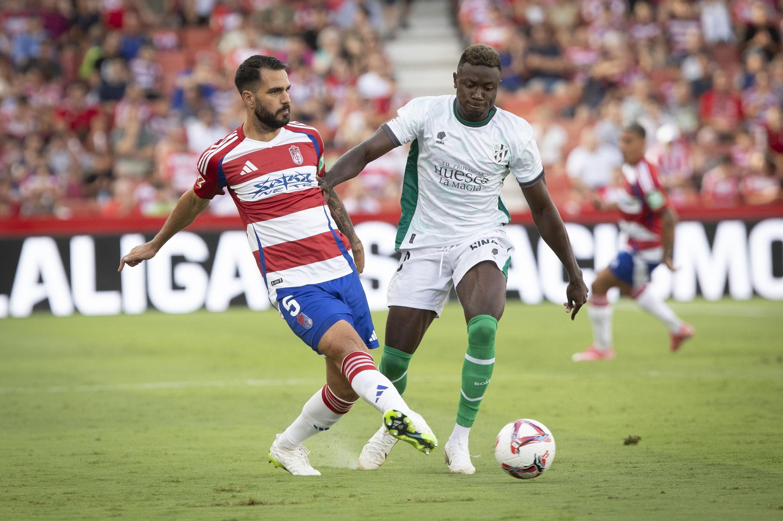 El delantero camerunés Patrick Soko presiona a un rival durante un encuentro disputado la pasada temporada con el Huesca.