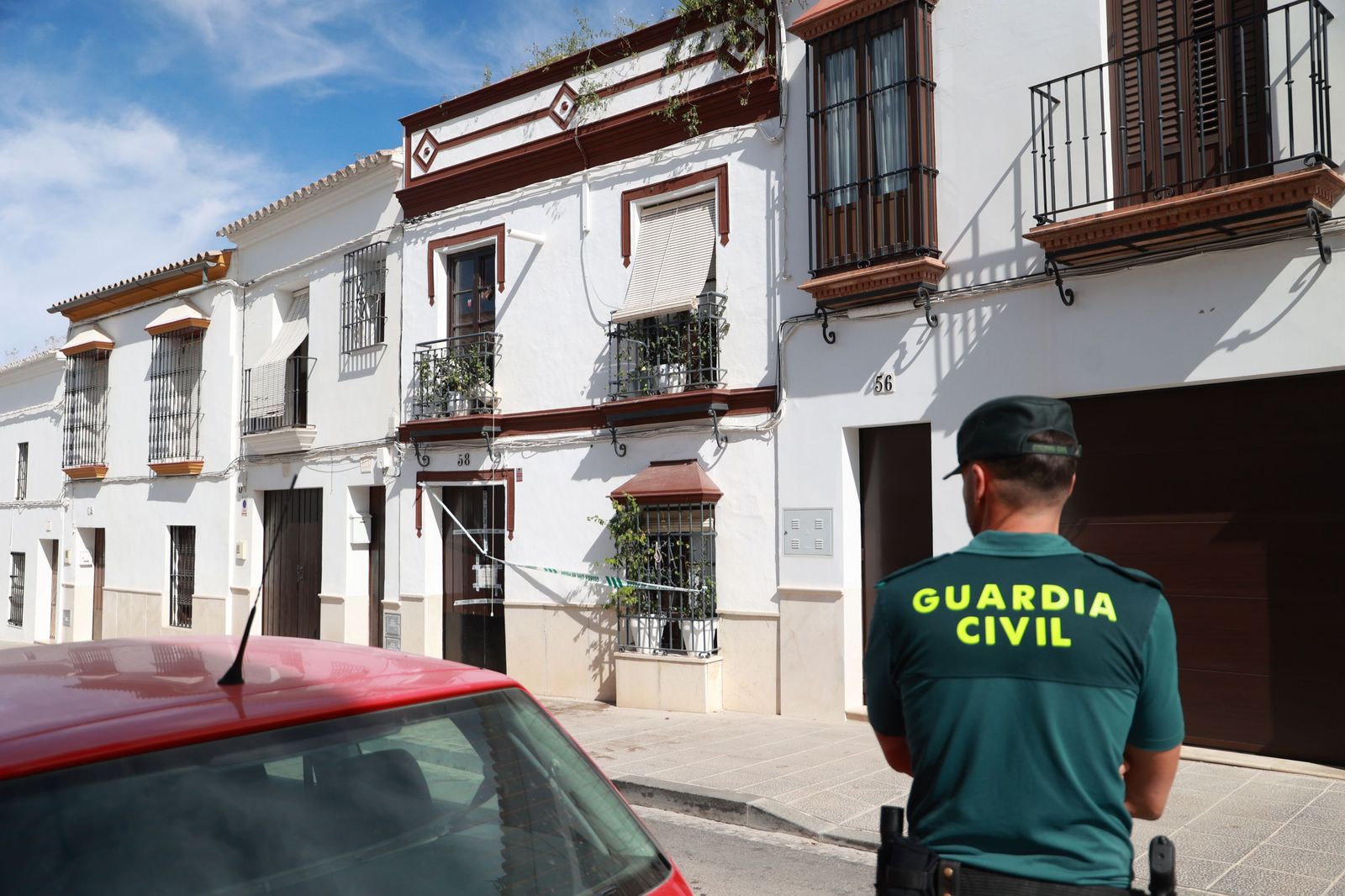 Un guardia civil custodia la casa de Osuna donde se hallaron dos cadáveres.