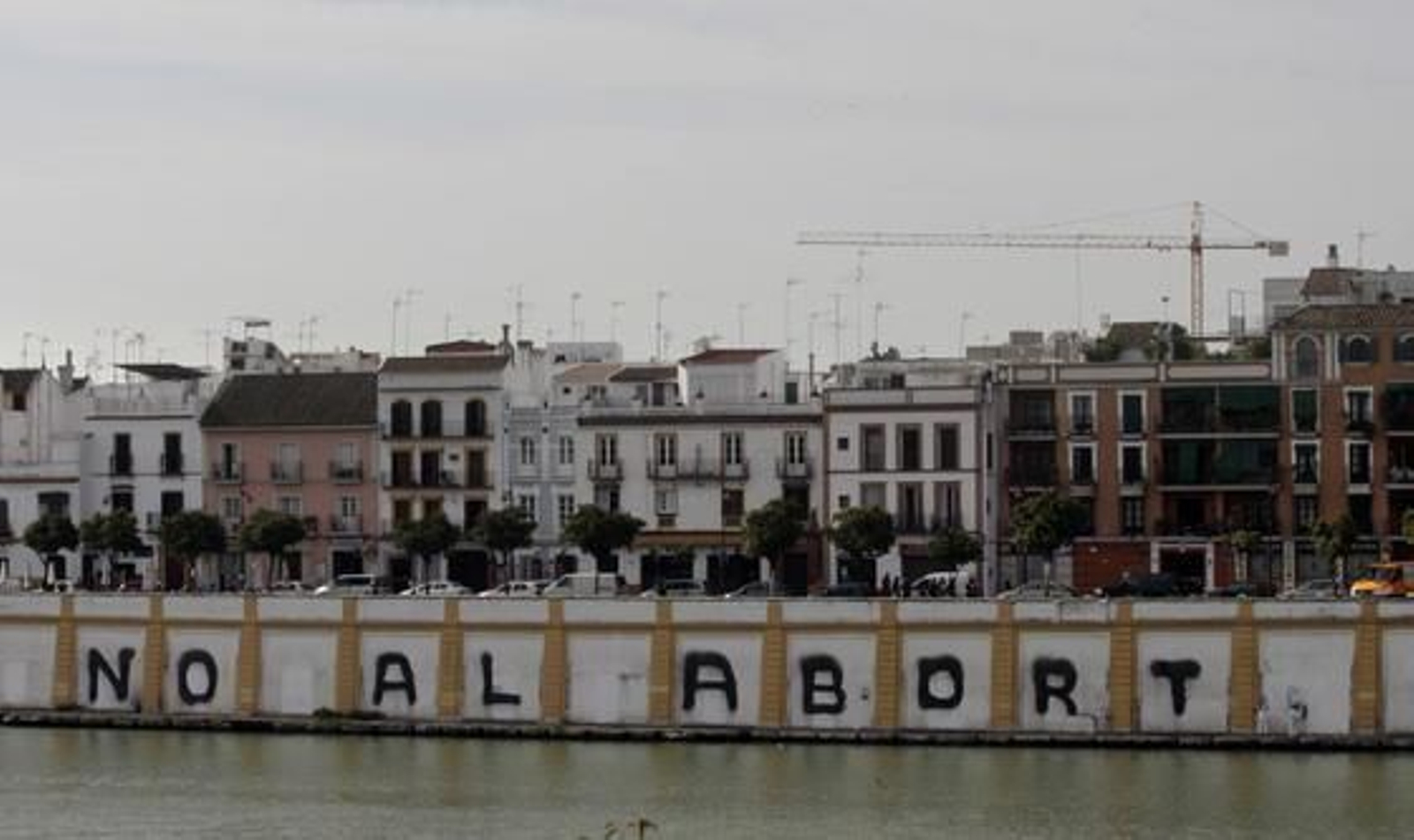 La frase "No al aborto", pintada en la fachada del río colindante con la calle Betis. / Juan Carlos Muñoz