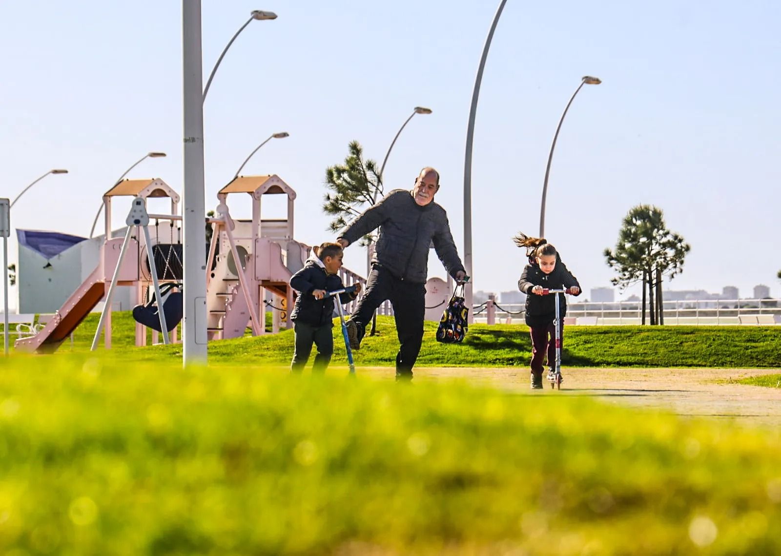 Un abuelo pasea y juega con sus nietos en Huelva.