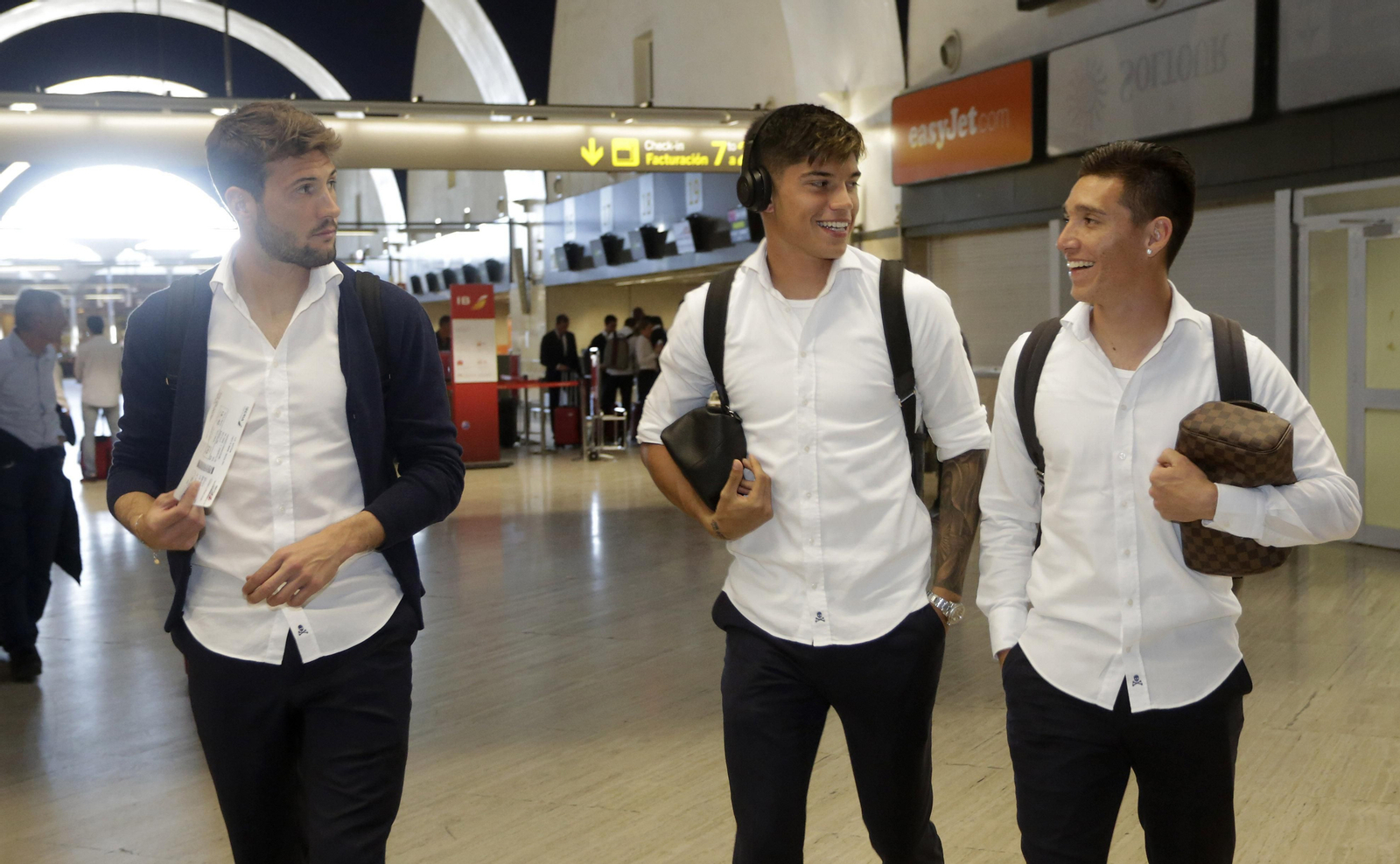 Franco Vázquez, Joaquín Correa y Matías Kranevitter, sonrientes antes de embarcar en el vuelo que los llevó a Barcelona.