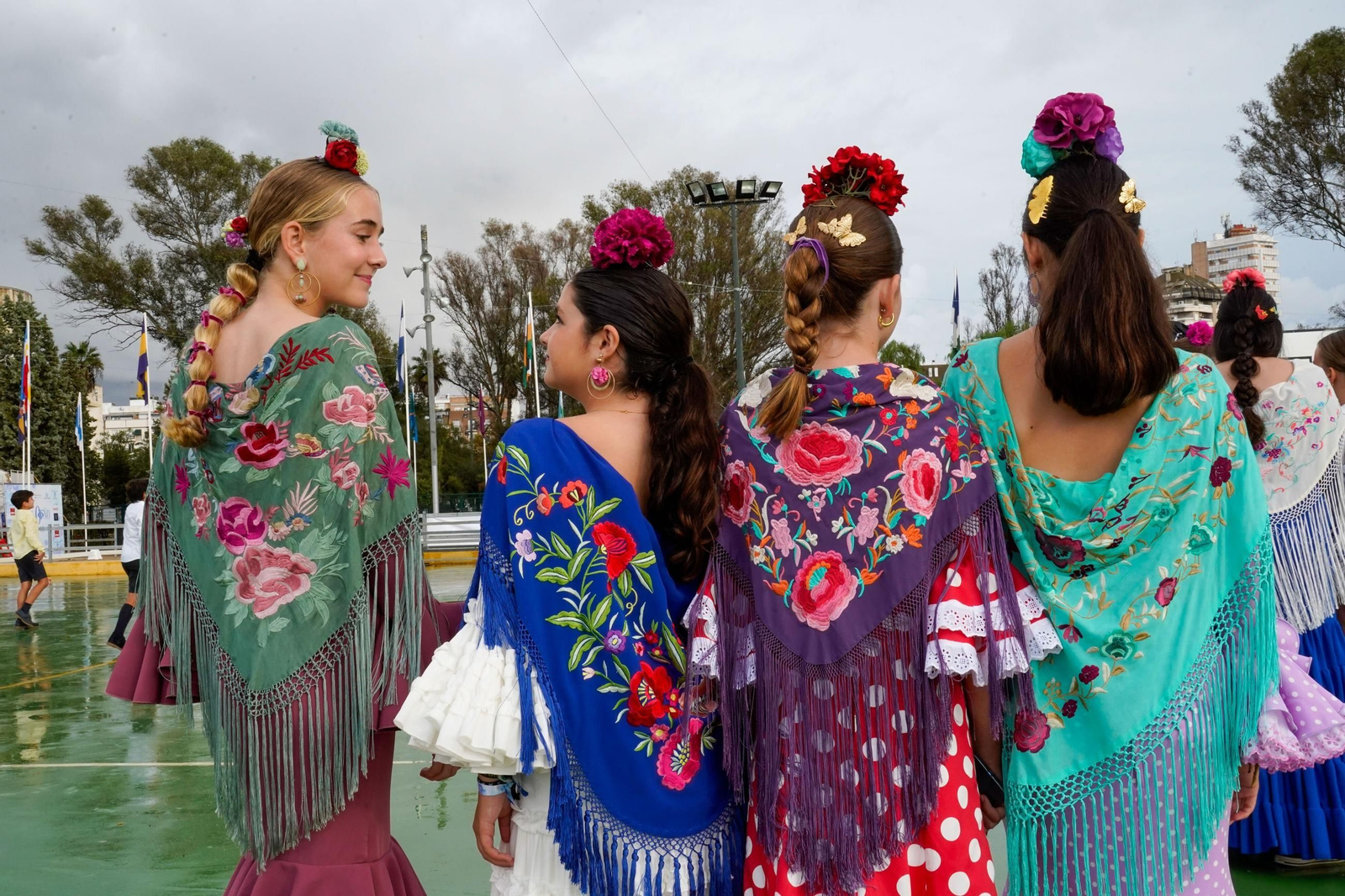 Un grupo de chicas lucen sus vestidos y mantoncillos en la Feria del Caballo de Huelva.