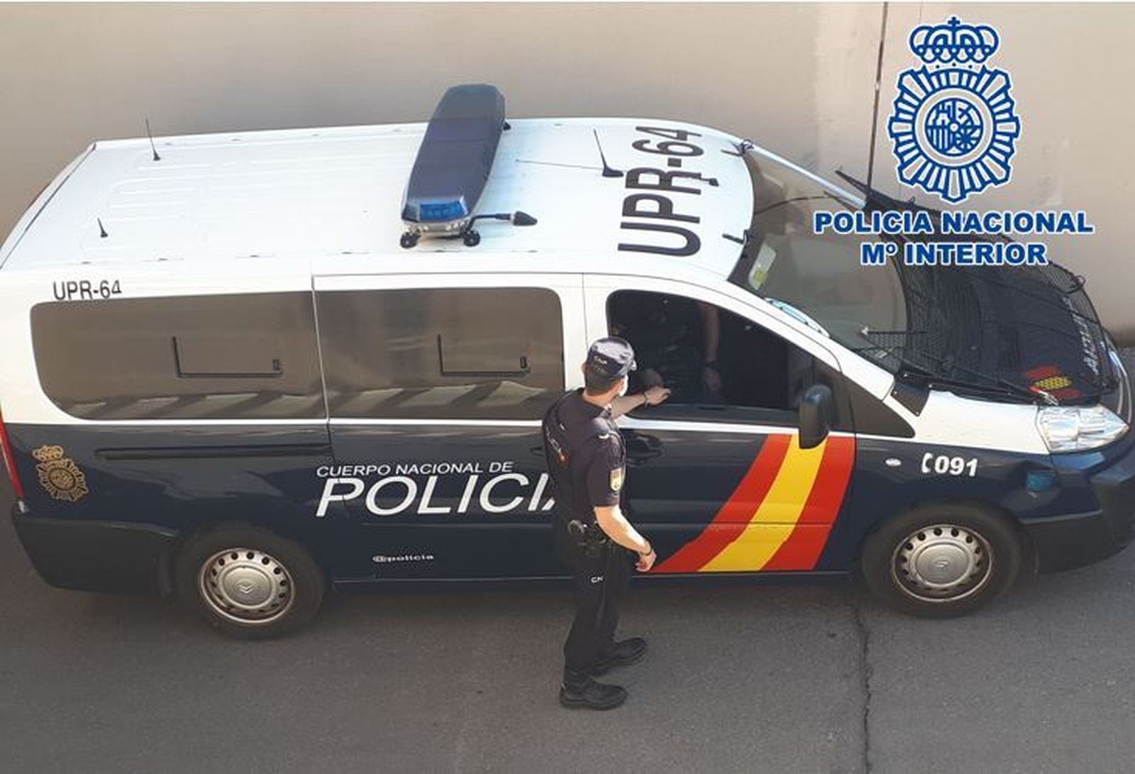 Imagen de archivo de un agente de la Policía Nacional junto a un vehículo policial.