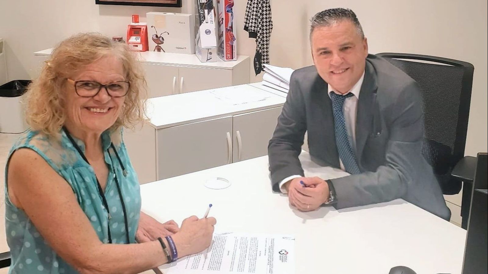 Firma del acuerdo entre la presidenta de la Asociación, Ana María Guerrero, y el gestor de Instituciones del banco Cajasur, José Ángel Miguel