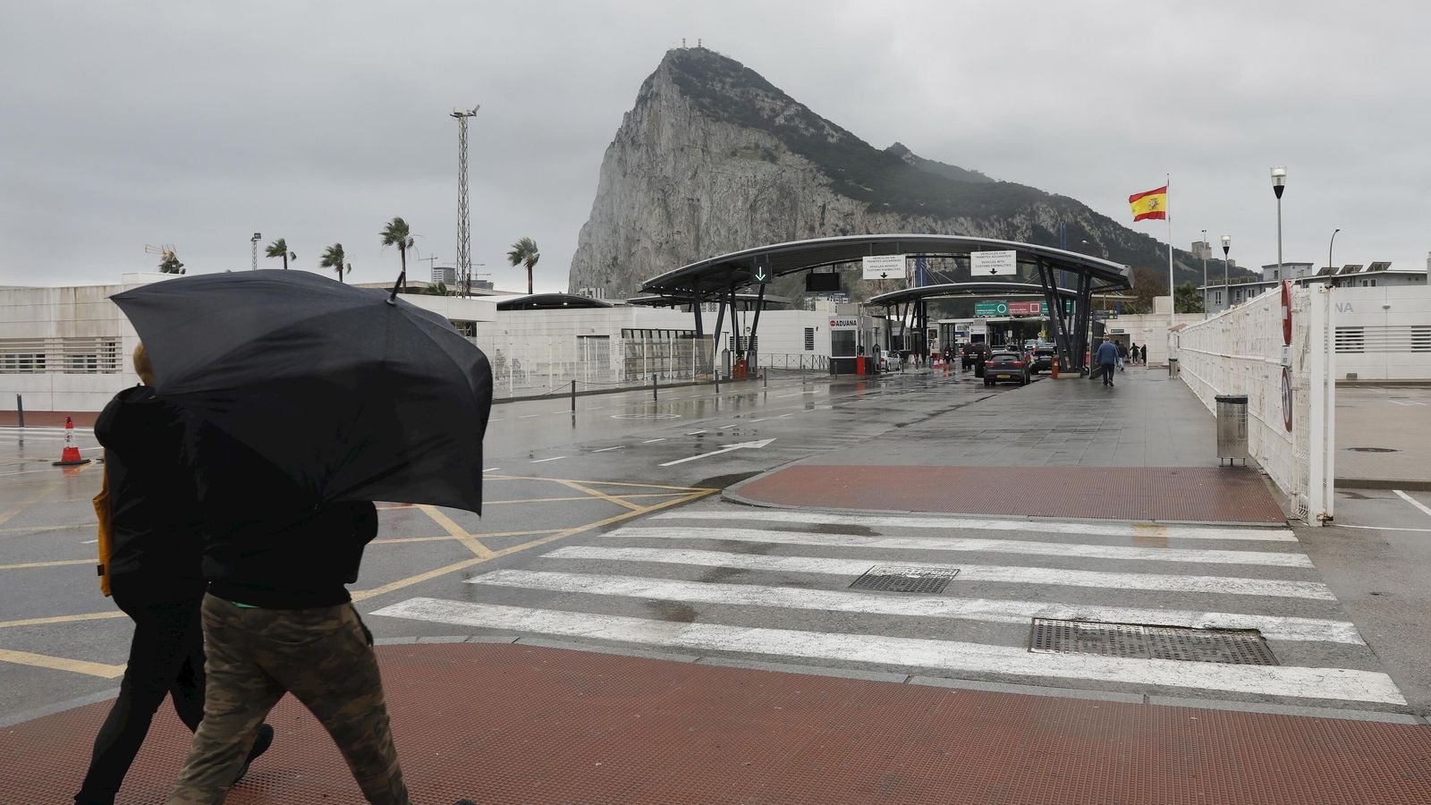Dos personas se refugian bajo un paraguas antes de entrar en Gibraltar.