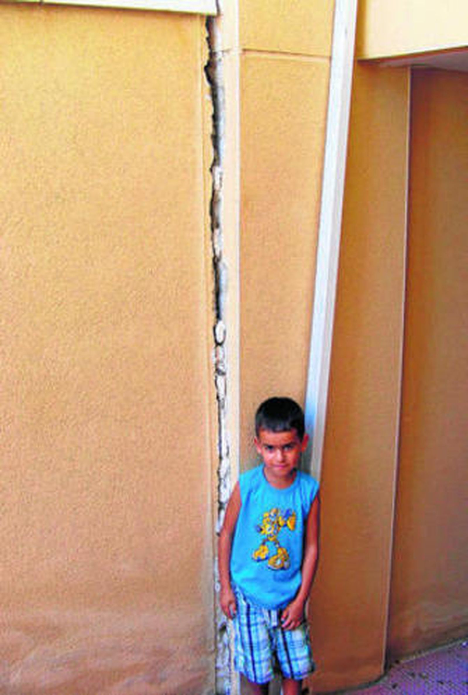 Un niño en el barrio del Bulevar junto a una grieta.