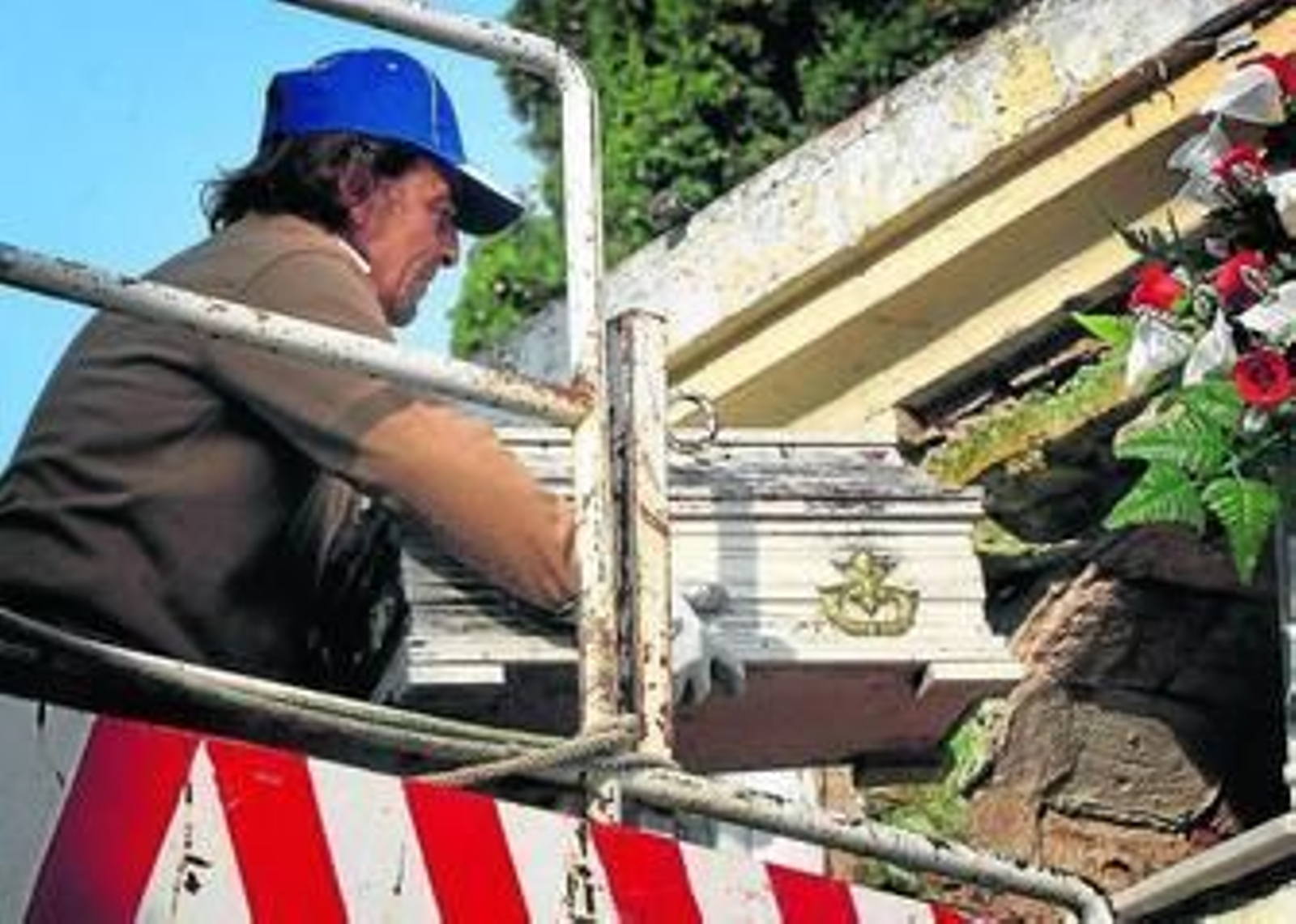 Un empleado del cementerio saca el féretro de un bebé, durante la última exhumación practicada en Jerez.