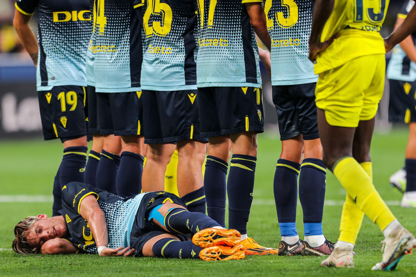 Iván Alejo se lanza el suelo para tapar el tiro de falta a ras de césped.