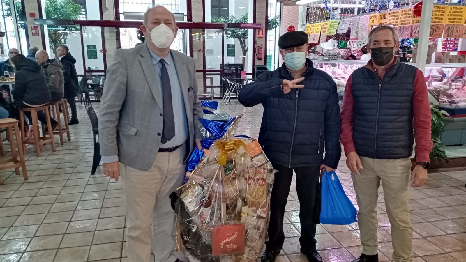 Entrega de una de las cestas de Navidad sorteadas en el Mercado Central.