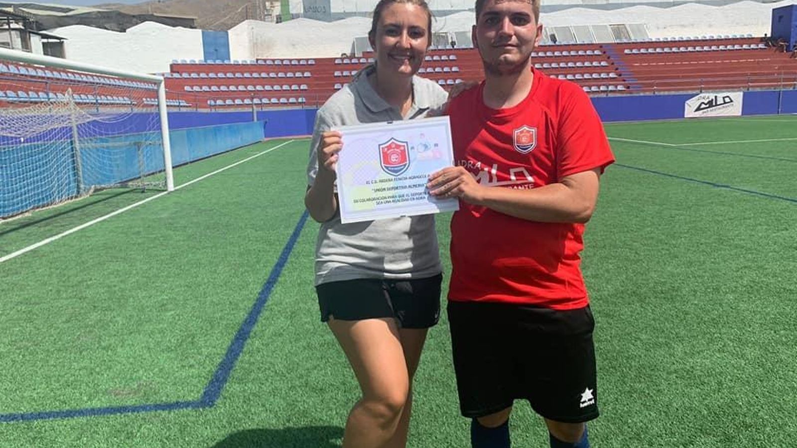 Lorena García y Dani Aguilar sostienen un diploma conmemorativo