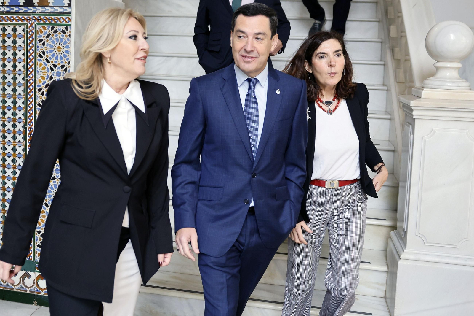 Juanma Moreno, escoltado por Carolina España y Rocío Blanco, en el Parlamento este jueves.