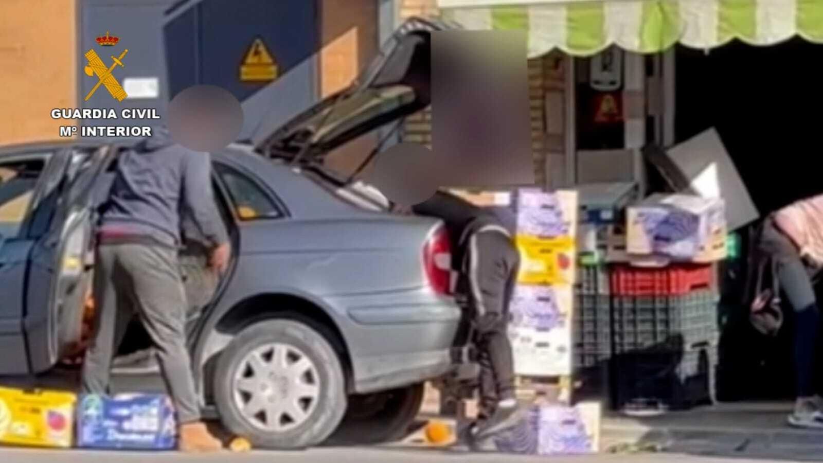 Los sospechosos descargan la fruta robada.