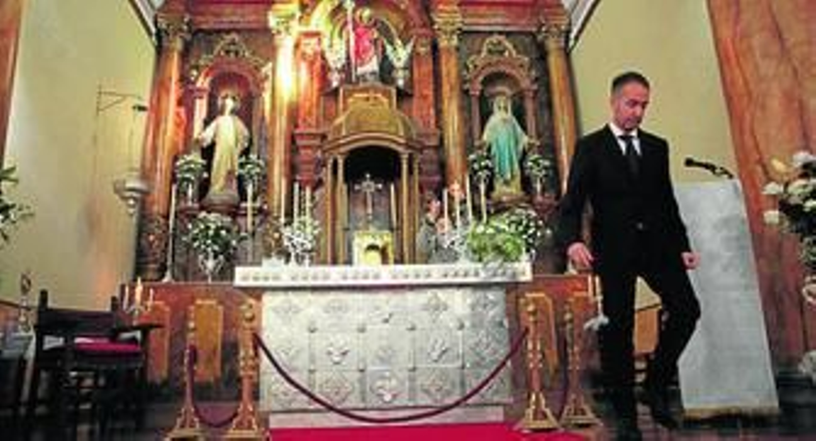 El autor junto a su obra, en la parroquia de San Isidro Benadalid.