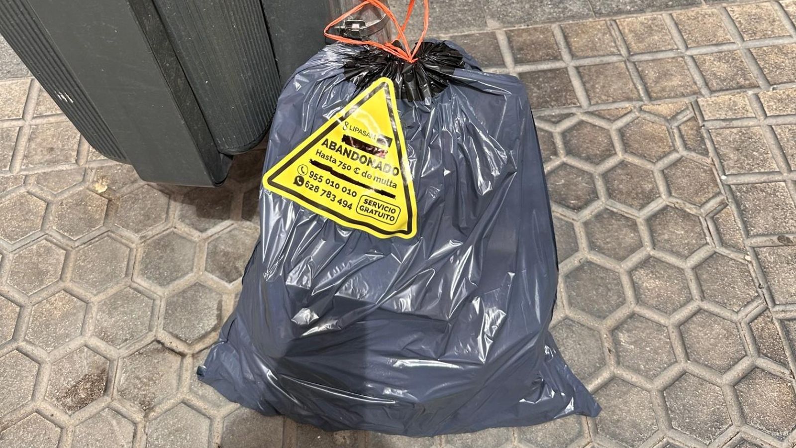 Una de las pegatinas que advierte de las consecuencias de abandonar las bolsas.