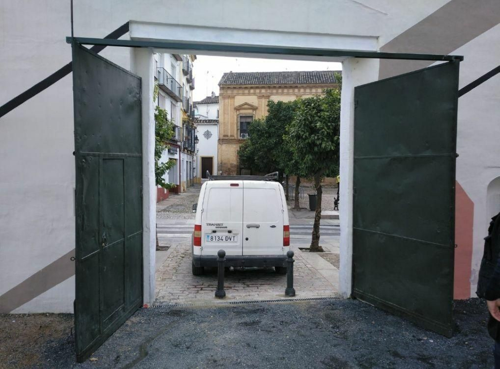 Portón del solar del antiguo Cine Andalucía abierto, con pivotes para evitar que entren los coches.