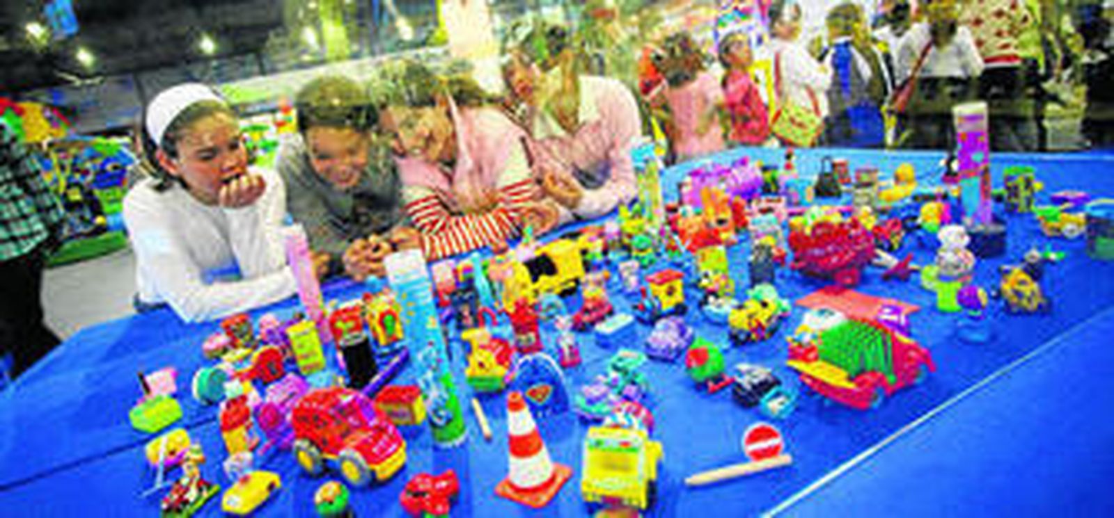 Varias niñas observan juguetes en una de las ediciones de MIMA.