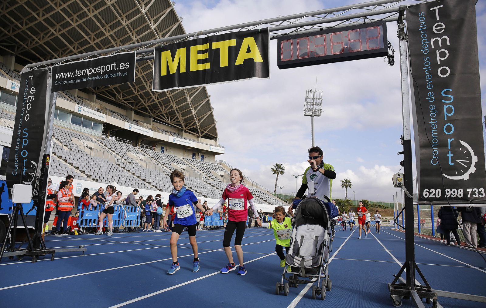Una familia alcanza la meta en el Estado de Atletismo de Málaga.