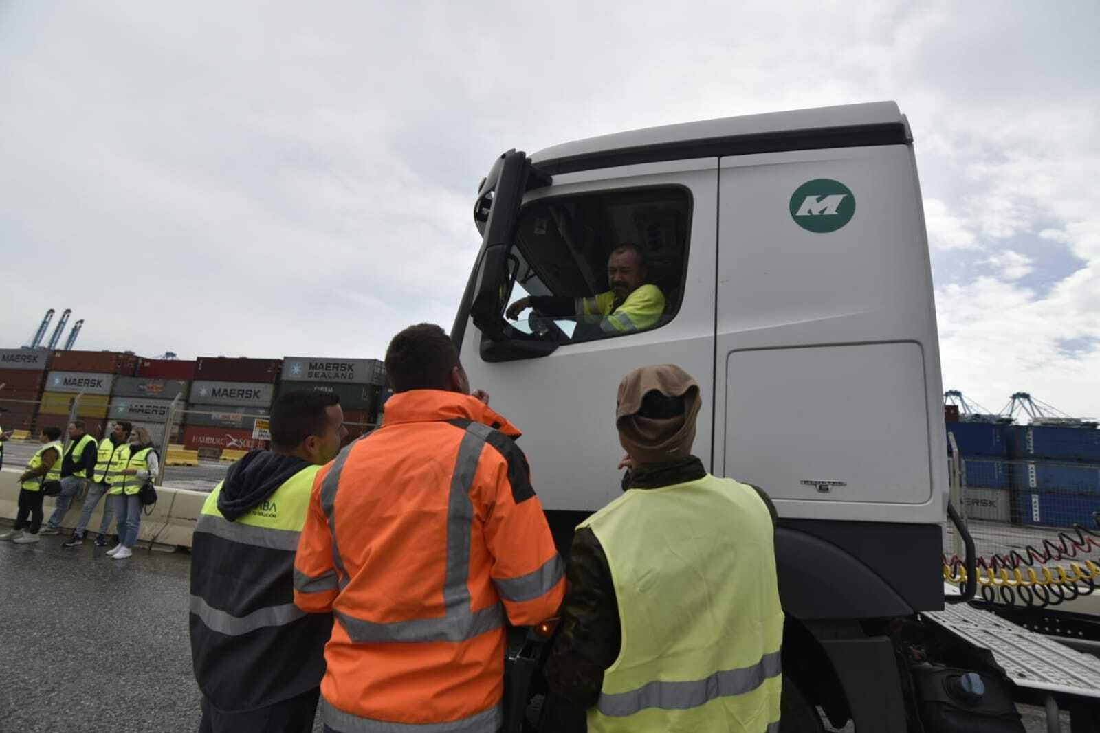 Tres camioneros de un piquete en el Puerto piden a otro que cese la actividad, este lunes.