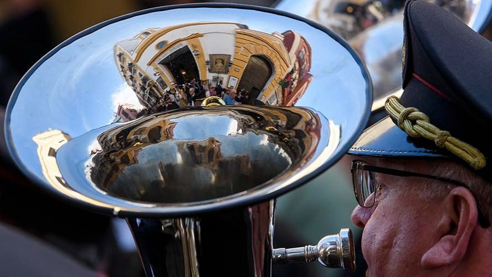 Un hombre tocando el trombón, creando un reflejo de su entorno