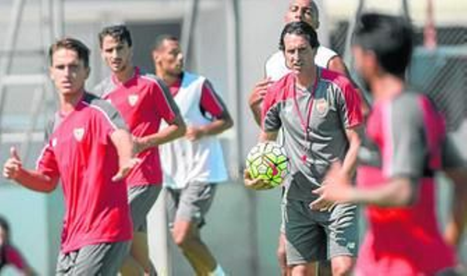 Unai Emery adiestra a sus hombres con un balón en la mano en una sesión de trabajo en la ciudad deportiva sevillista, este verano.