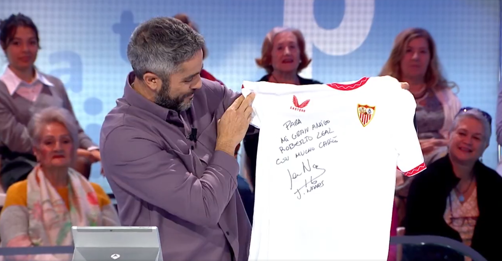 Roberto Leal lee la dedicatoria de Jesús Navas en la camiseta del Sevilla.