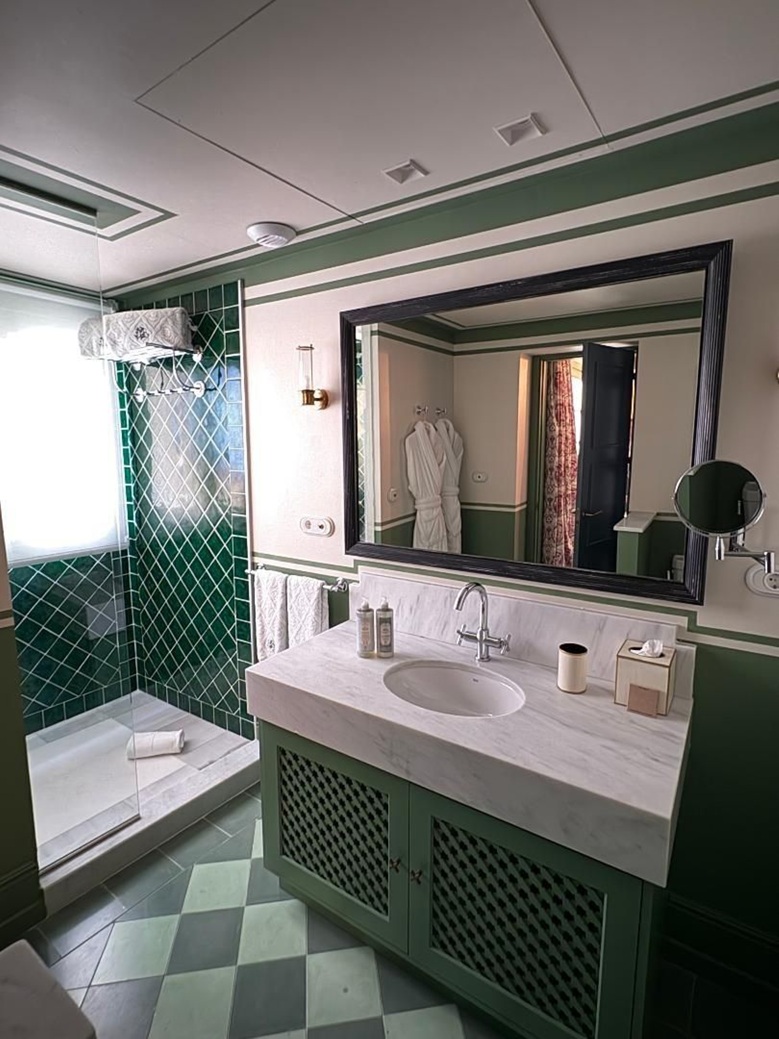 Baño. Utiliza en  su decoración el mármol blanco y azulejos azules en espigas.