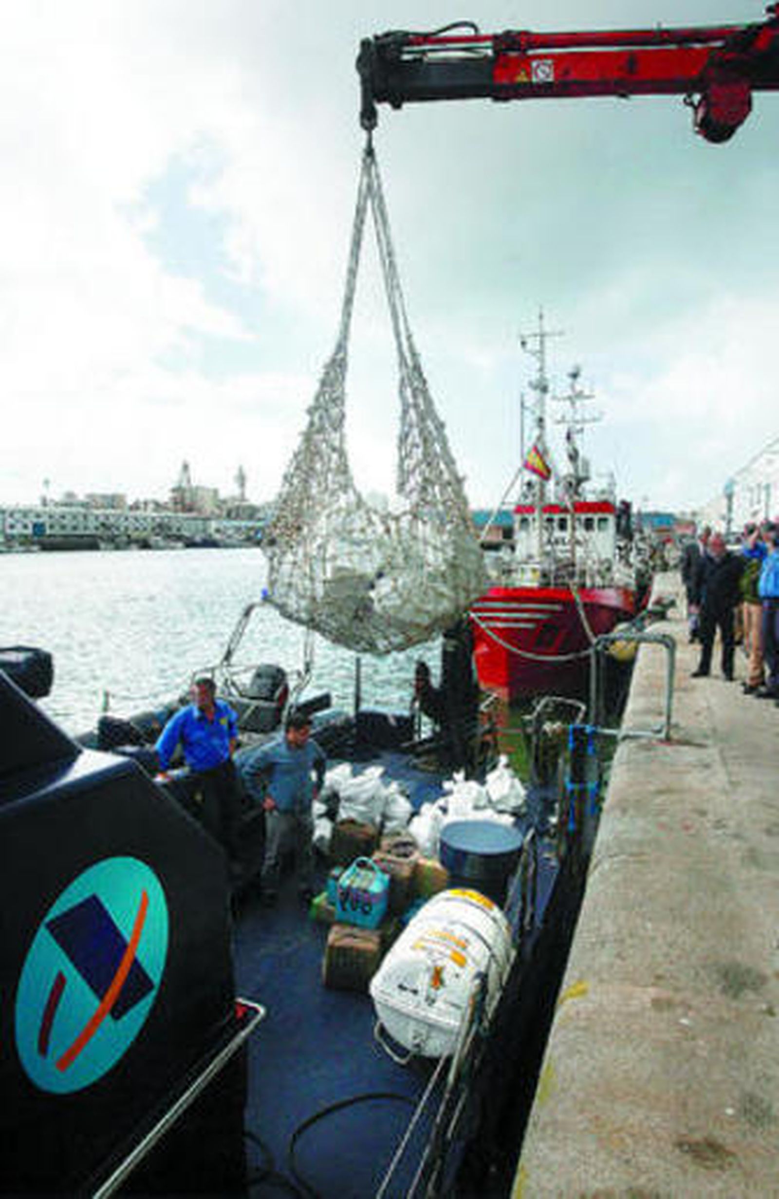 EN FALSOS TANQUES EN POPA. La droga iba oculta a bordo del yate 'Tania', atracado en el muelle de Cádiz: en las imágenes, momento de la descarga, foto oficial del alijo y detalle de la embarcación interceptada.