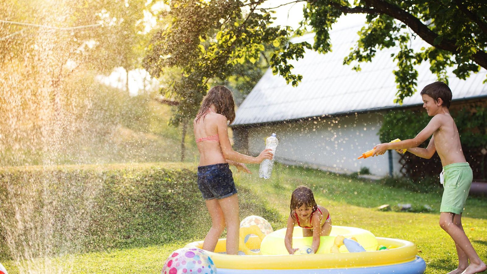 Niños jugando en la piscina hinchable.