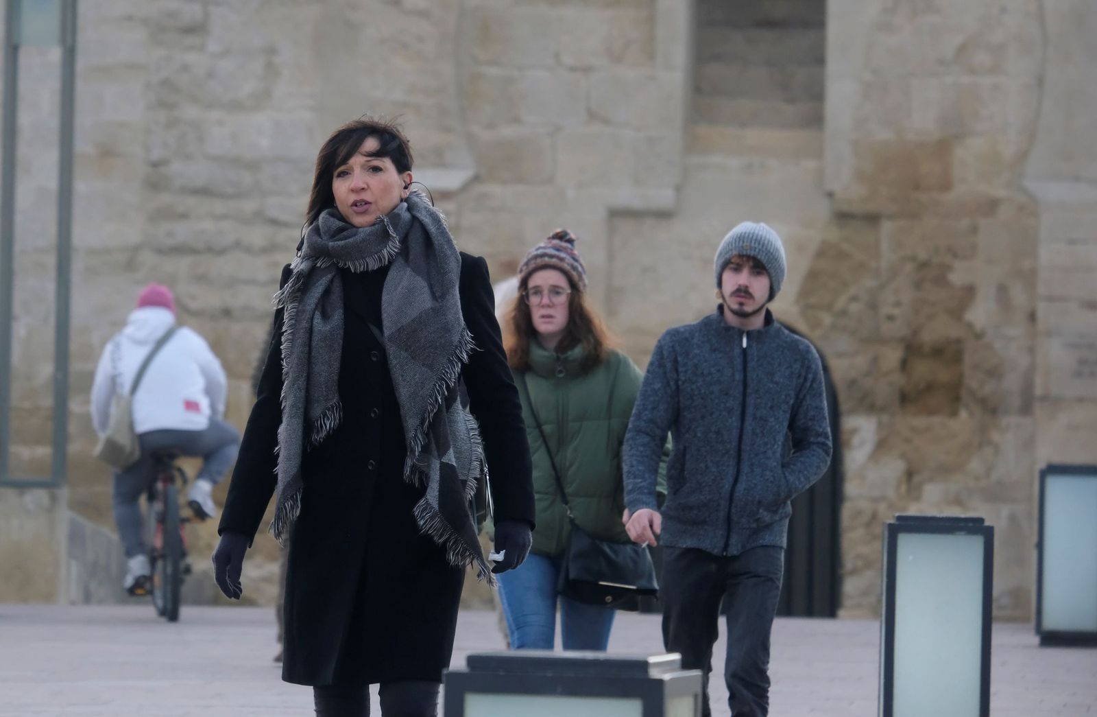 Varias personas caminan abrigadas por el Puente Romano de Córdoba.