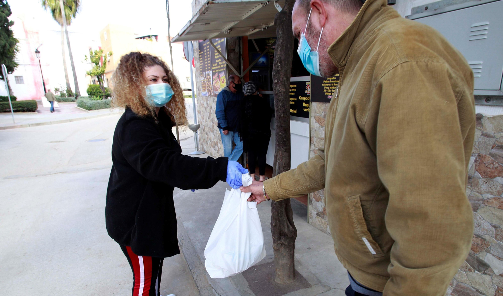 Una empleada del Asador Eva entrega uno de los menús ofertados.