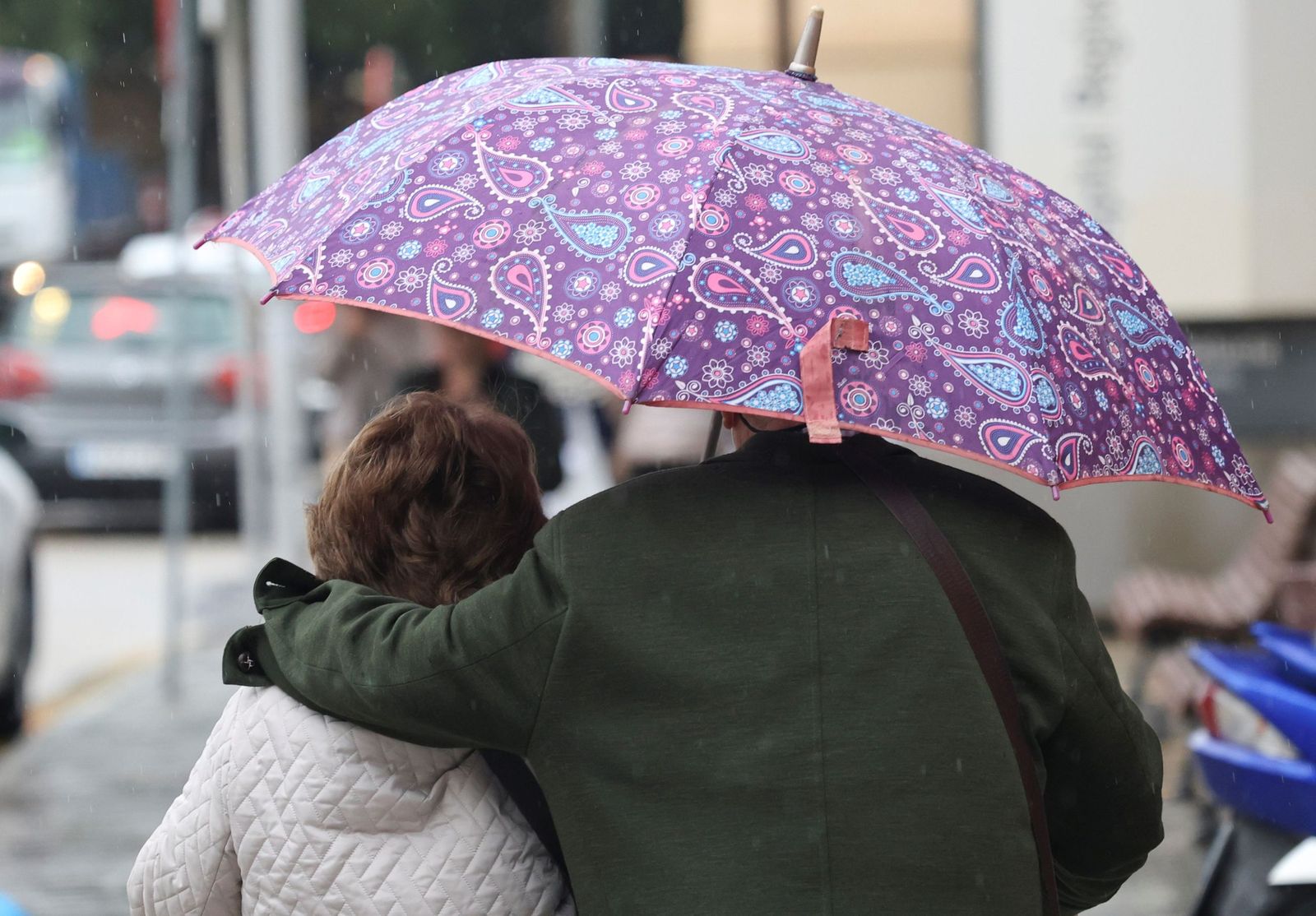 Los dos cabemos bajo este paraguas y así no nos mojamos.