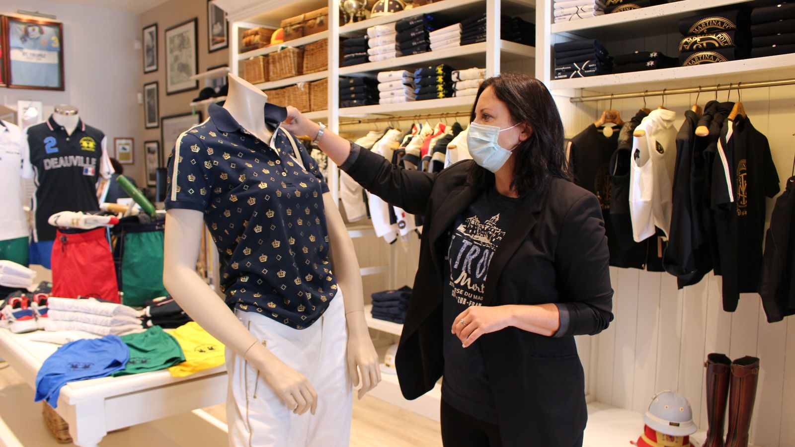 Vista de una comerciante acomodando la ropa.