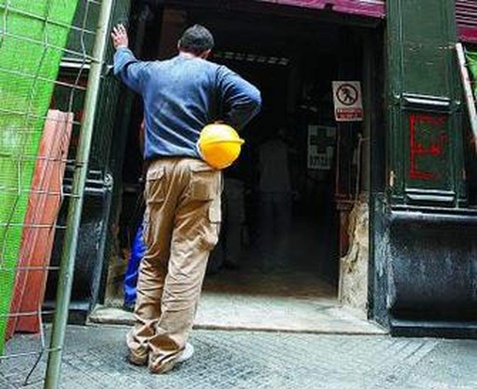 Compañeros del herido, a las puertas de la obra tras el accidente.