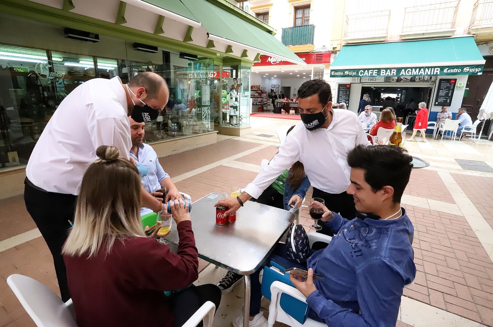 Un camarero sirve Coca-Cola durante la desescalada en Huelva.