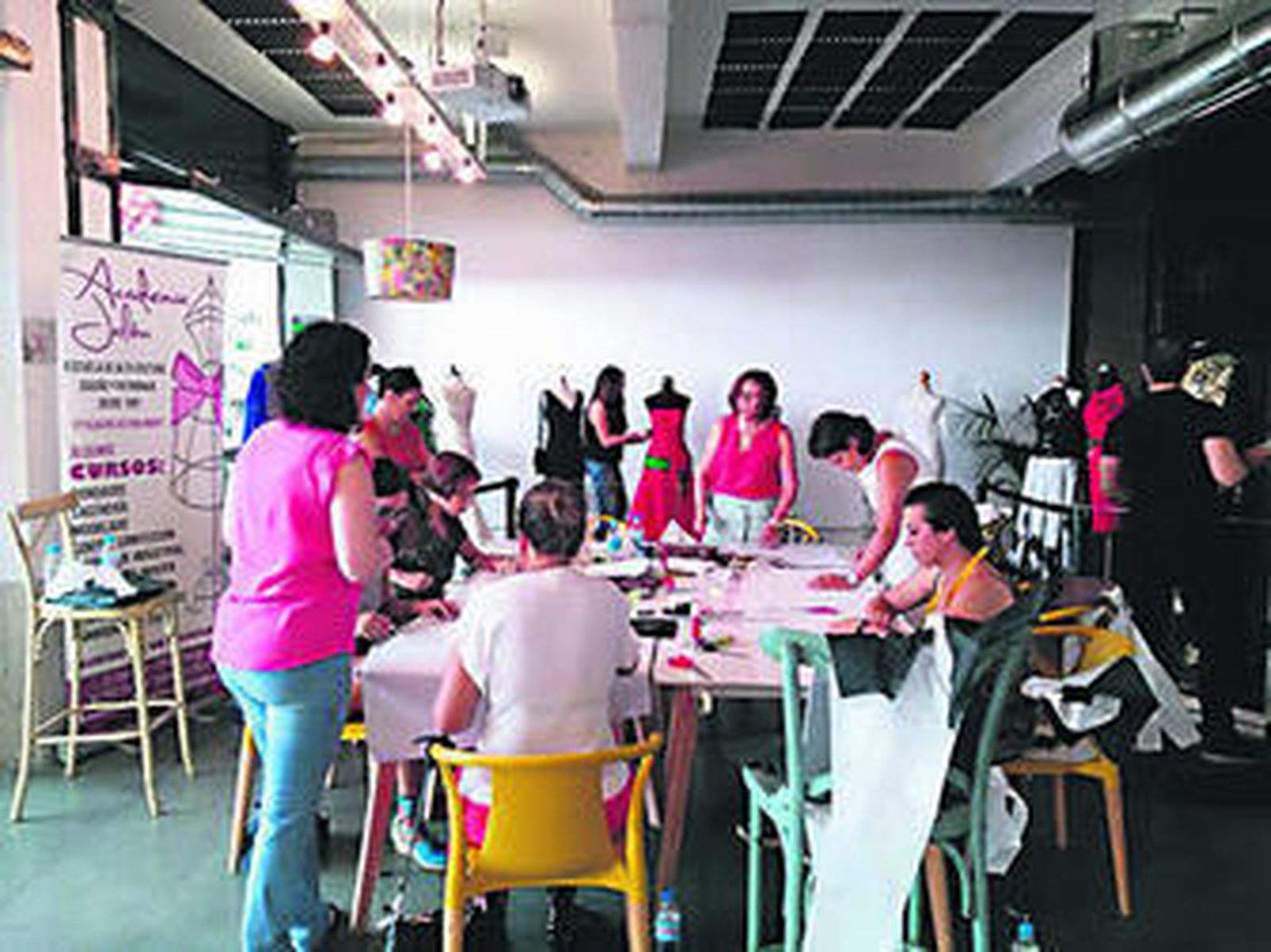 Alumnas en el Mercado de la Merced junto con los maniquíes que portan vestidos