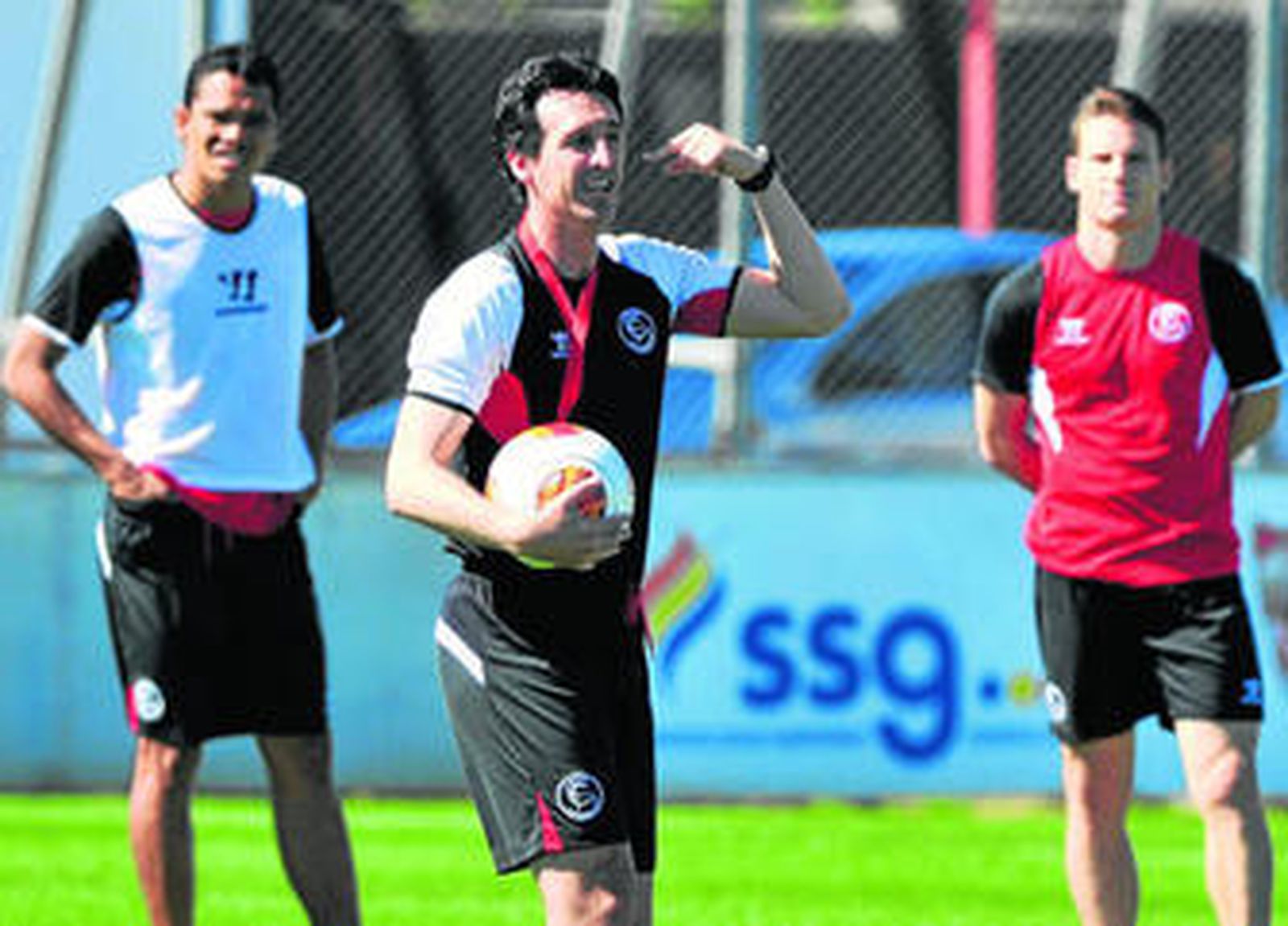 Unai Emery, en el entrenamiento de ayer, da instrucciones respaldado por los dos goleadores del Sevilla, Bacca y Gameiro.