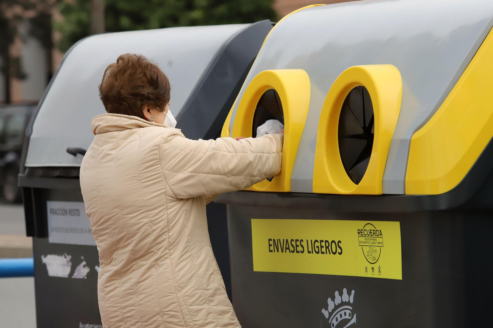 Una mujer recicla en el contenedor de plásticos en Huelva.
