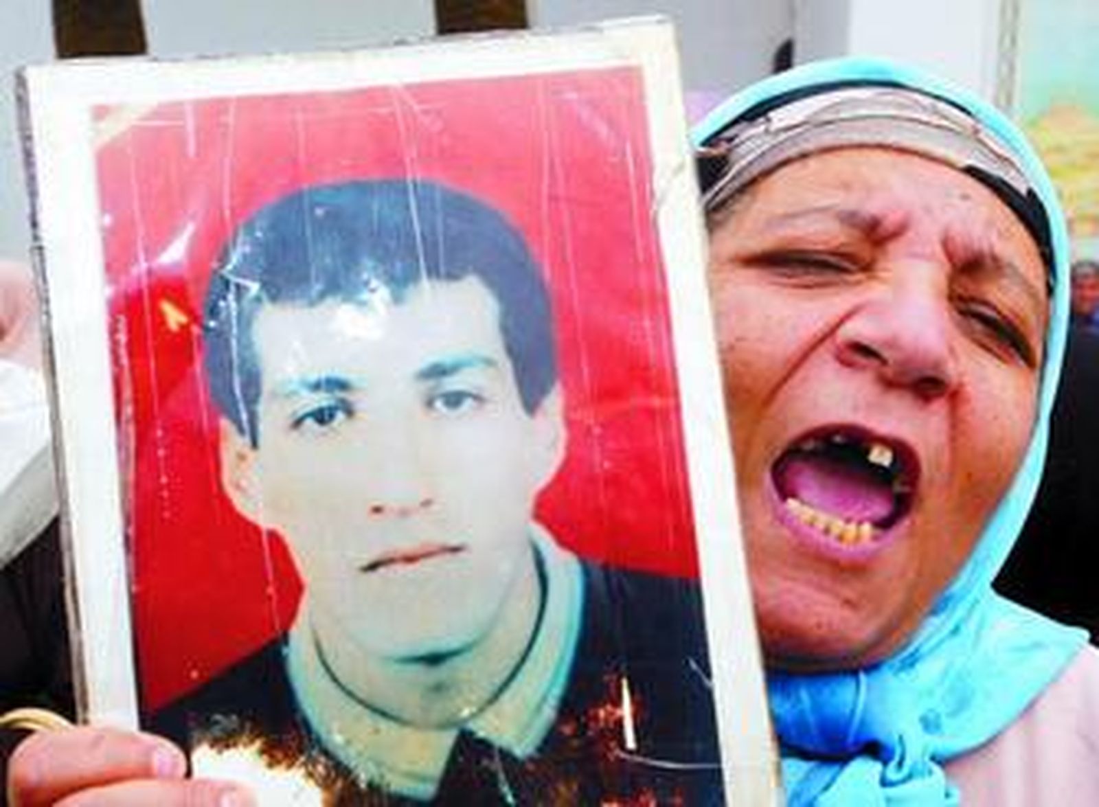 Una mujer argelina muestra una foto de un familiar muerto en enfrentamientos.