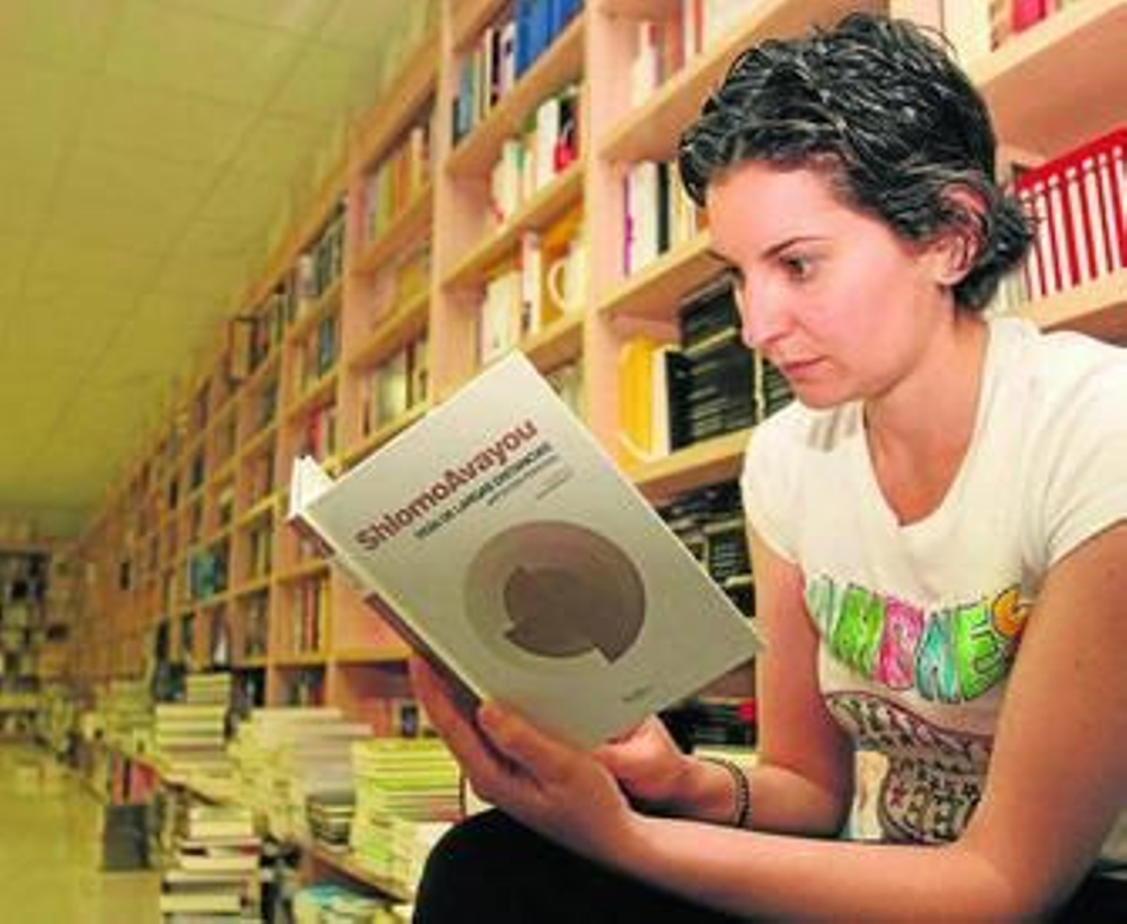 Una joven lee en una tienda de libros.
