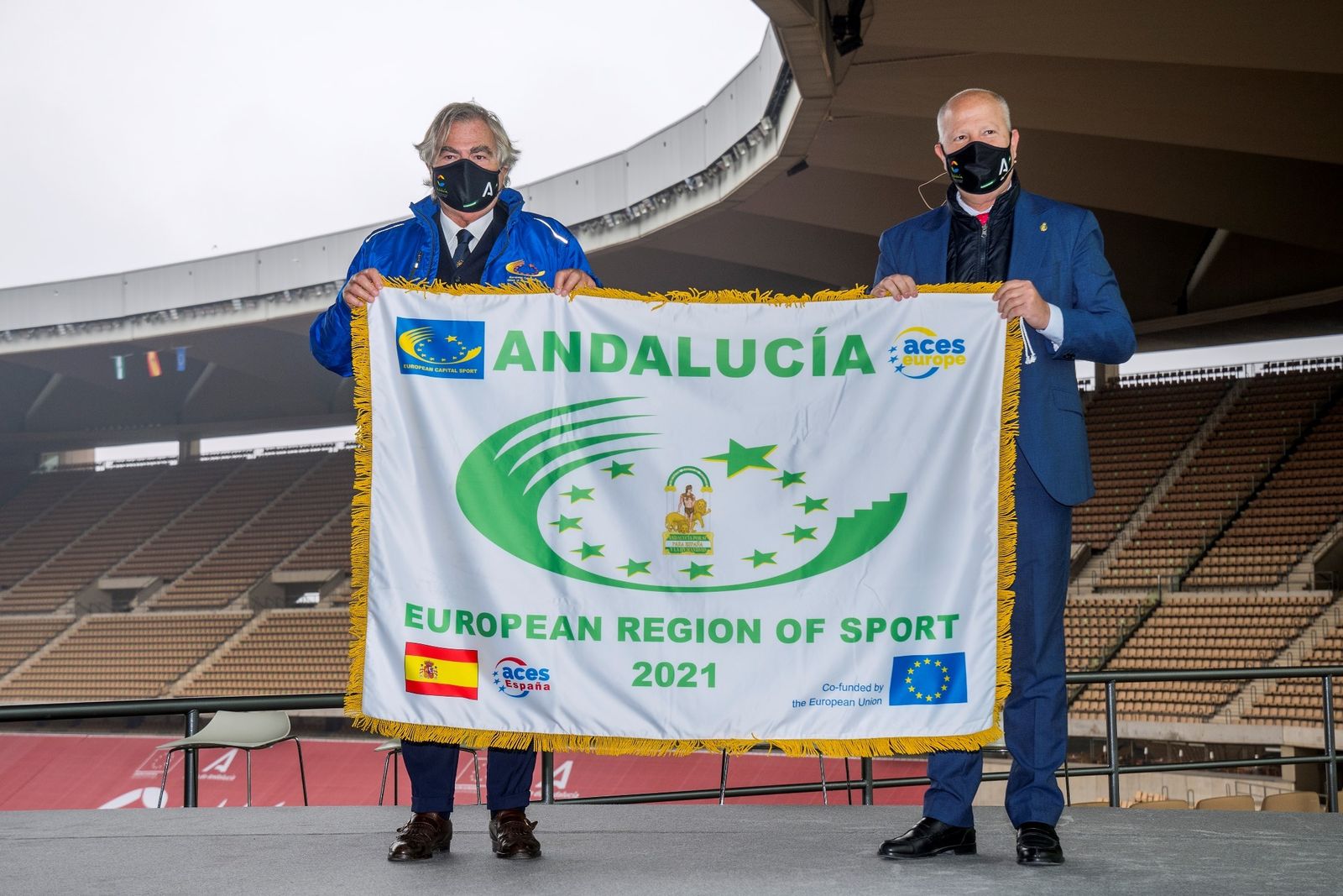 El presidente de ACES Europe, Gian Francesco Lupattelli, muestra junto a Javier Imbroda la bandera de la región del deporte.