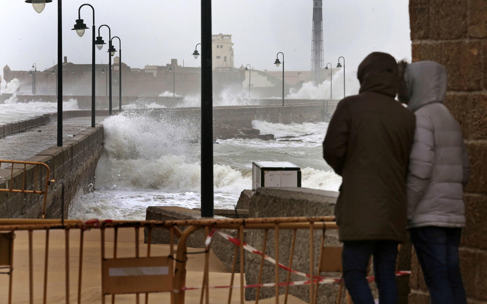 Dos personas observan los efectos del temporal que azotó Cádiz el pasado mes de marzo.
